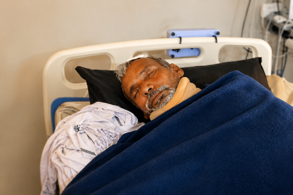 Patient resting in a hospital bed during recovery after receiving expert trauma care following a serious roof fall.